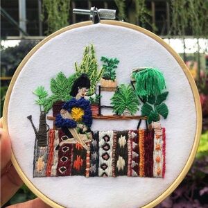 PLANT LADY SITTING ON RUG Embroidered Art